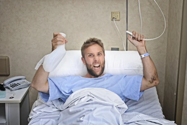 Angry patient man at hospital room lying in bed pressing nurse call button holding potty — Stock Photo, Image