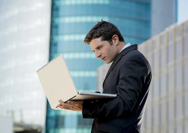 Giovane uomo d'affari in possesso di computer portatile che lavora affari urbani all'aperto — Foto Stock