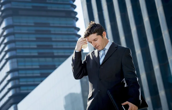 Young exhausted and worried businessman standing outdoors in stress and depression — Stock Photo, Image