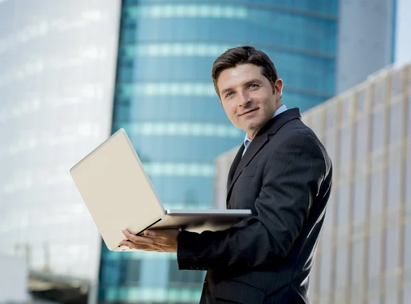 Young businessman holding computer laptop working urban business outdoors — Stock Photo, Image