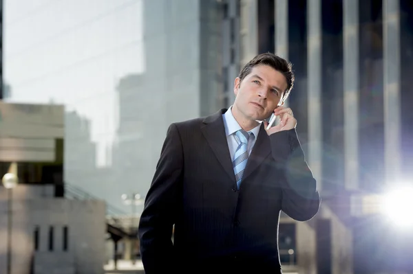 Joven atractivo hombre de negocios en traje y corbata hablando por teléfono móvil feliz al aire libre — Foto de Stock