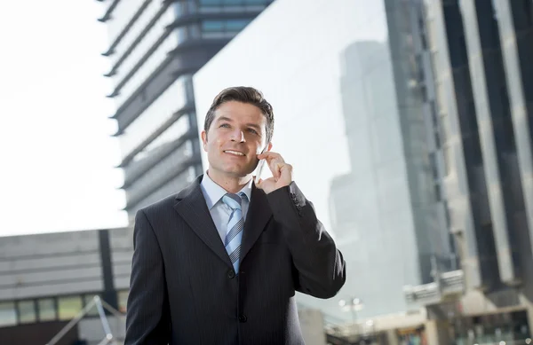 Fiatal, vonzó üzletember az öltöny és a nyakkendő beszél a mobiltelefon boldog szabadban — Stock Fotó