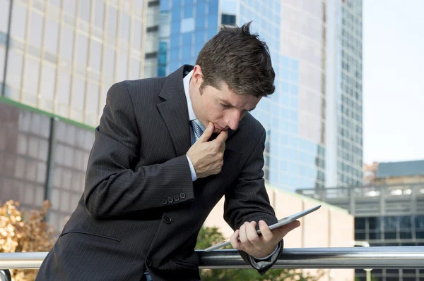 Бизнесмен держит цифровой планшет стоя на открытом воздухе, работая на открытом воздухе бизнес-район — стоковое фото