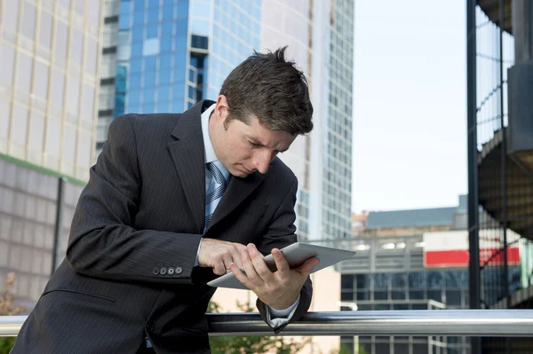 Uomo d'affari che tiene tablet digitale all'aperto lavorando all'aperto quartiere degli affari — Foto Stock