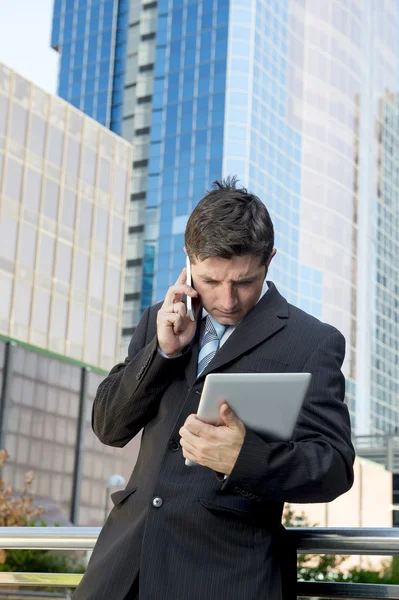Upptagen affärsman håller digital tablet och mobiltelefon överarbetad utomhus — Stockfoto