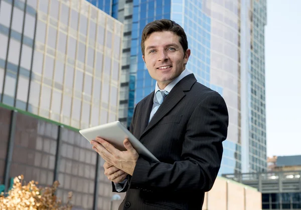 Corporate stående ung affärsman arbetar med digital tablet utomhus — Stockfoto