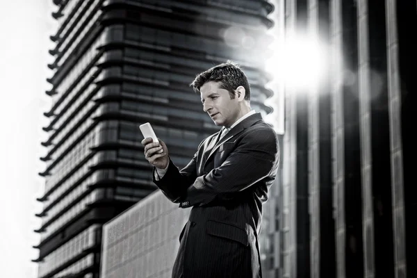 Attraente uomo d'affari in giacca e cravatta guardando messaggio di testo al telefono cellulare — Foto Stock