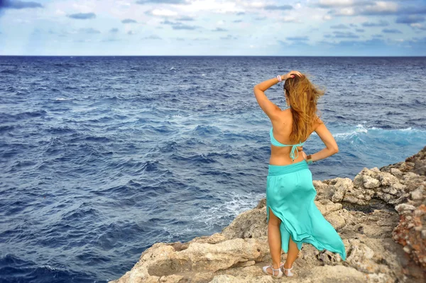 Attraente donna guardando orizzonte marino in piedi su roccia scogliera — Foto Stock