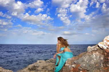 attractive woman looking at sea horizon thoughtful from rock cliff  in relax concept