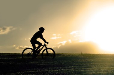 profile silhouette sport man riding cross country mountain bike