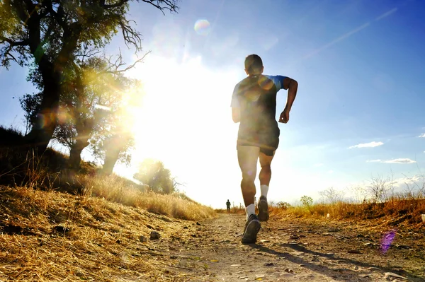 Силует молодого спортивного чоловіка, що біжить з перехресного змагання на літньому заході сонця — стокове фото