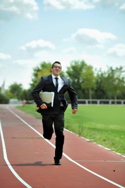 businessman running fast on athletic track in work stress and urgency concept