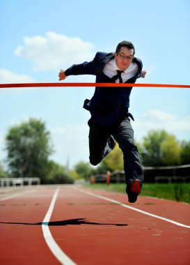 businessman running on athletic track celebrating victory in work success concept