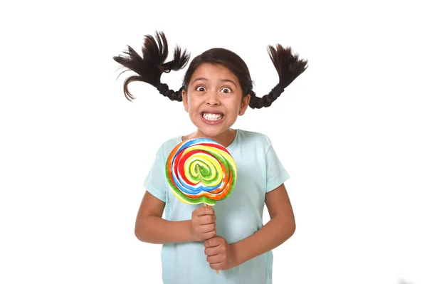 Happy child holding big lollipop candy with pony tails flying in freak crazy funny face — Stockfoto