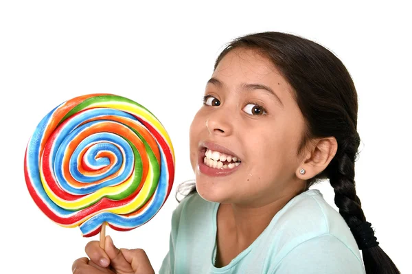 Happy female child holding big lollipop candy in cheerful face expression in kid love for sweet concept — Zdjęcie stockowe