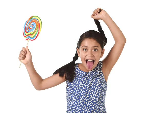 Happy female child holding big lollipop candy pulling pony tail with crazy funny face expression in sugar addiction — Zdjęcie stockowe