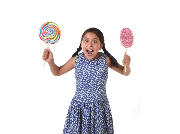 Happy female child holding two big lollipop in crazy funny face expression in sugar addiction — Zdjęcie stockowe