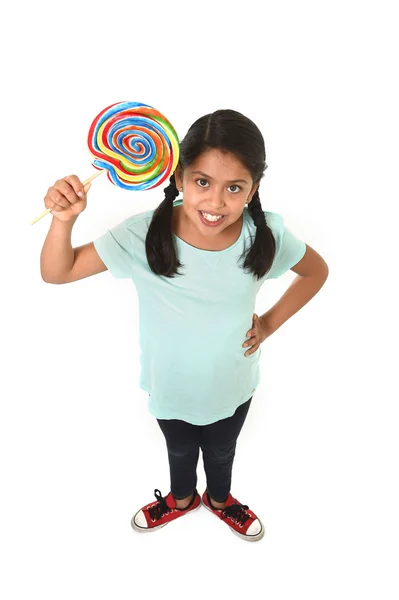 Child holding big lollipop candy in cheerful face expression in sugar addiction — ストック写真