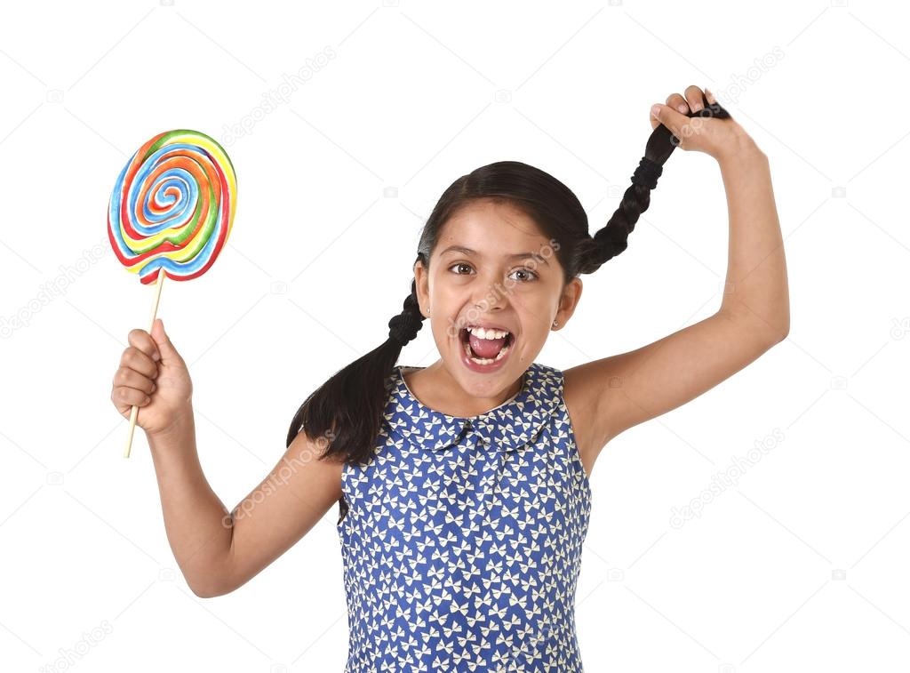happy female child holding big lollipop candy pulling pony tail with crazy funny face expression in sugar addiction