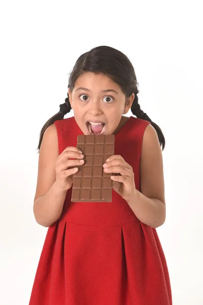 Happy female girl in red dress holding with both hands big chocolate eating in happy excited face expression in sugary nutrition — Stockfoto