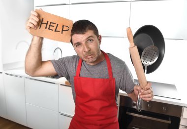 funny scared man holding pan wearing apron at kitchen asking for