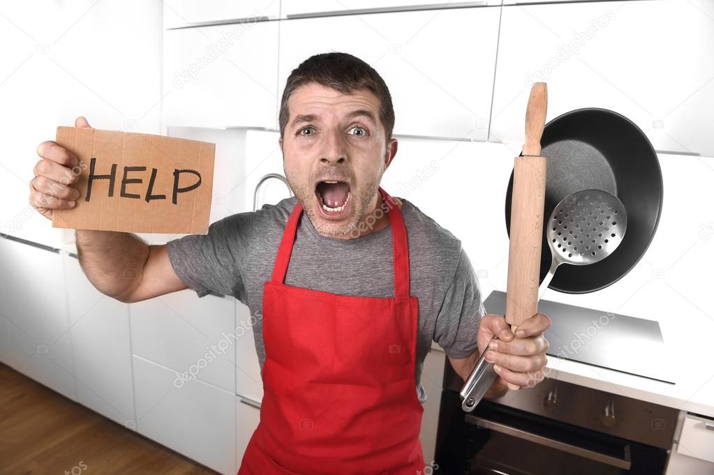 funny scared man holding pan wearing apron at kitchen asking for