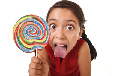 sugar addict latin female child holding huge lollipop candy eating and licking happy crazy excited clipart