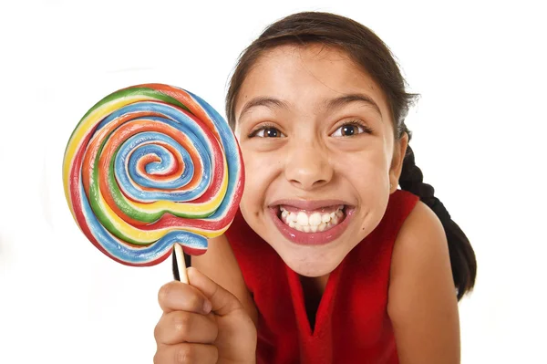 Sugar addict latin female child holding big lollipop candy eating and licking happy crazy excited — 图库照片