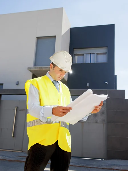 Young attractive architect worker supervising building blueprints outdoors wearing construction helmet — Stok fotoğraf