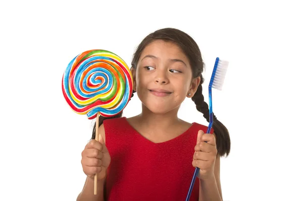 Cute female child holding big spiral lollipop candy and huge too — ストック写真