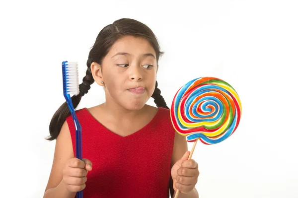 Cute female child holding big spiral lollipop candy and huge too — Stok fotoğraf