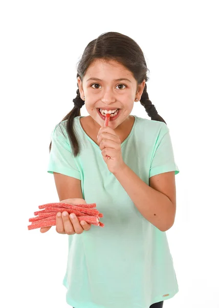 Happy cute female child licking and eating red licorice candy in kid love sweet and sugar concept — Stock Photo, Image