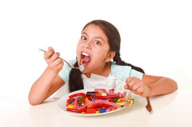mutlu bir Latin kadın çocuk şeker ve gummies w tam yemek yeme