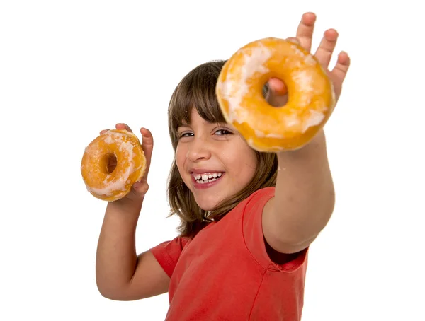 Happy beautiful female child having fun playing with two sugar donuts smiling excited — Zdjęcie stockowe