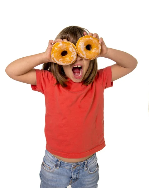 Happy female child having fun playing with two sugar donuts in the eyes smiling excited — Stockfoto