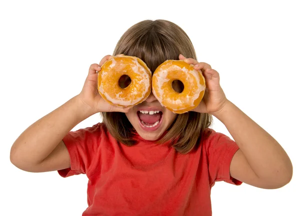 Happy female child having fun playing with two sugar donuts in the eyes smiling excited — Stockfoto