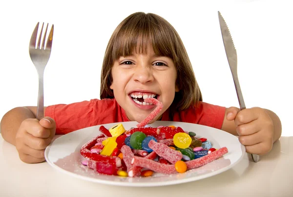 Child eating candy like crazy in sugar abuse and unhealthy sweet nutrition concept — Stockfoto