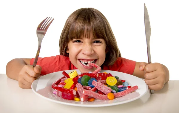 Anak makan permen seperti gila dalam penyalahgunaan gula dan tidak sehat konsep nutrisi manis Stok Gambar