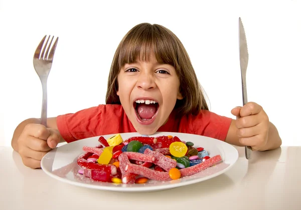 Anak makan permen seperti gila dalam penyalahgunaan gula dan tidak sehat konsep nutrisi manis Stok Gambar Bebas Royalti