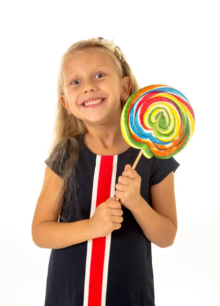 Beautiful female child with long blond hair holding huge spiral lollipop candy smiling happy — Stockfoto