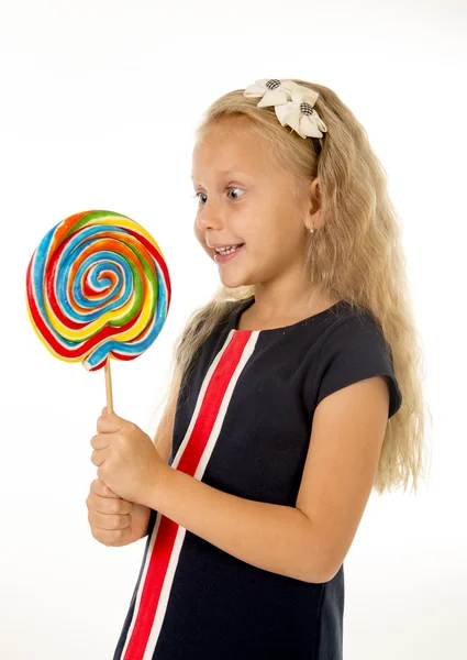 Schöne weibliche Kind mit langen blonden Haaren essen lecken riesige Spirale Lutscher Bonbons lächeln glücklich — Stockfoto