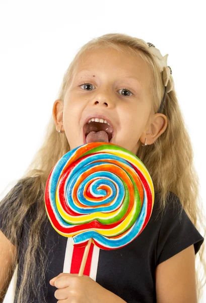 , bella femmina bambino con lunghi capelli biondi mangiare leccare enorme spirale caramelle lecca lecca sorridente felice — Foto Stock