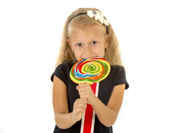 Mooie vrouwelijke kind met lang blond haar eten likken enorme spiraal lollipop snoep glimlachend gelukkig — Stockfoto