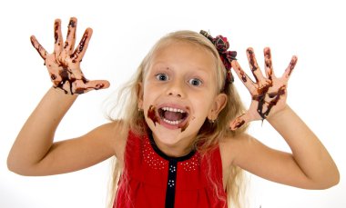 pretty little female child with long blond hair and blue eyes wearing red dress showing dirty hands with stains of chocolate syrup