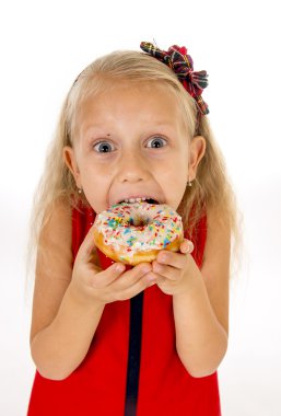 little beautiful female child with long blonde hair and red dress eating sugar donut with toppings delighted and happy