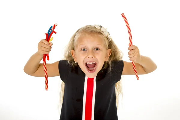 Beautiful little female child with blue eyes eating strawberry licorice candy — 图库照片