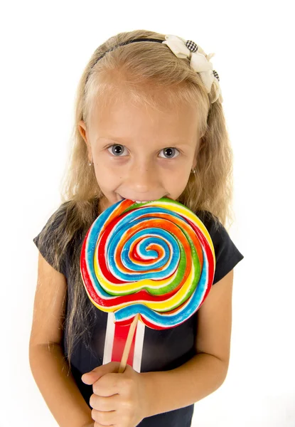 Beautiful little female child with sweet blue eyes eating huge lollipop spiral candy smiling happy — ストック写真