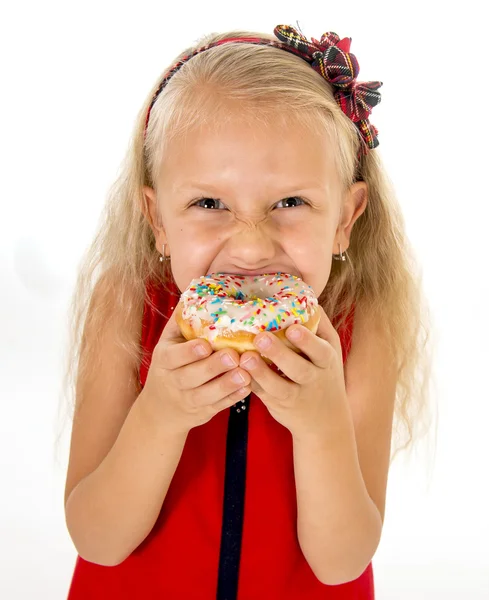 Little beautiful female child with long blonde hair and red dress eating sugar donut with toppings delighted and happy — ストック写真