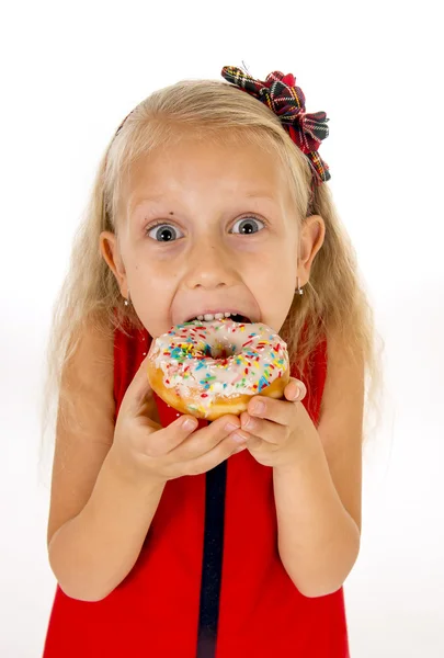 Маленька красива жінка з довгим світлим волоссям і червоною сукнею їсть цукровий пончик з начинками в захваті і щасливі — стокове фото