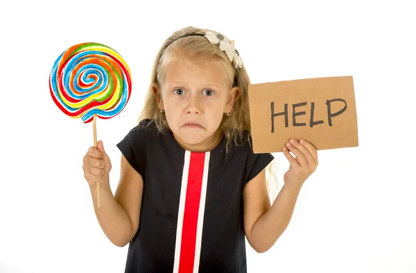 Pretty little child holding lollipop and help sign in children sugar excess and sweet diet abuse unhealthy nutrition concept — Stock Photo, Image
